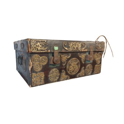 baúl rectangular de almacenamiento con un acabado exterior oscuro revestido en cuero, caracterizado por ricos herrajes metálicos dorados con grabados y motivos ornamentales tradicionales, cierres frontales y asas laterales alquiler para eventos, publicidad, peliculas y series