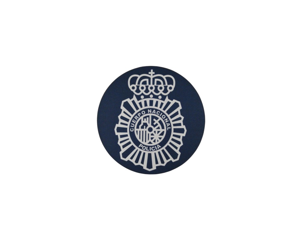 A circular fabric patch in dark blue, featuring the official emblem of the Spanish National Police Force embroidered or printed in light colours, comprising the eight-pointed star, the central coat of arms and the royal crown at the top. Available for hire for events, advertising, films and TV series.