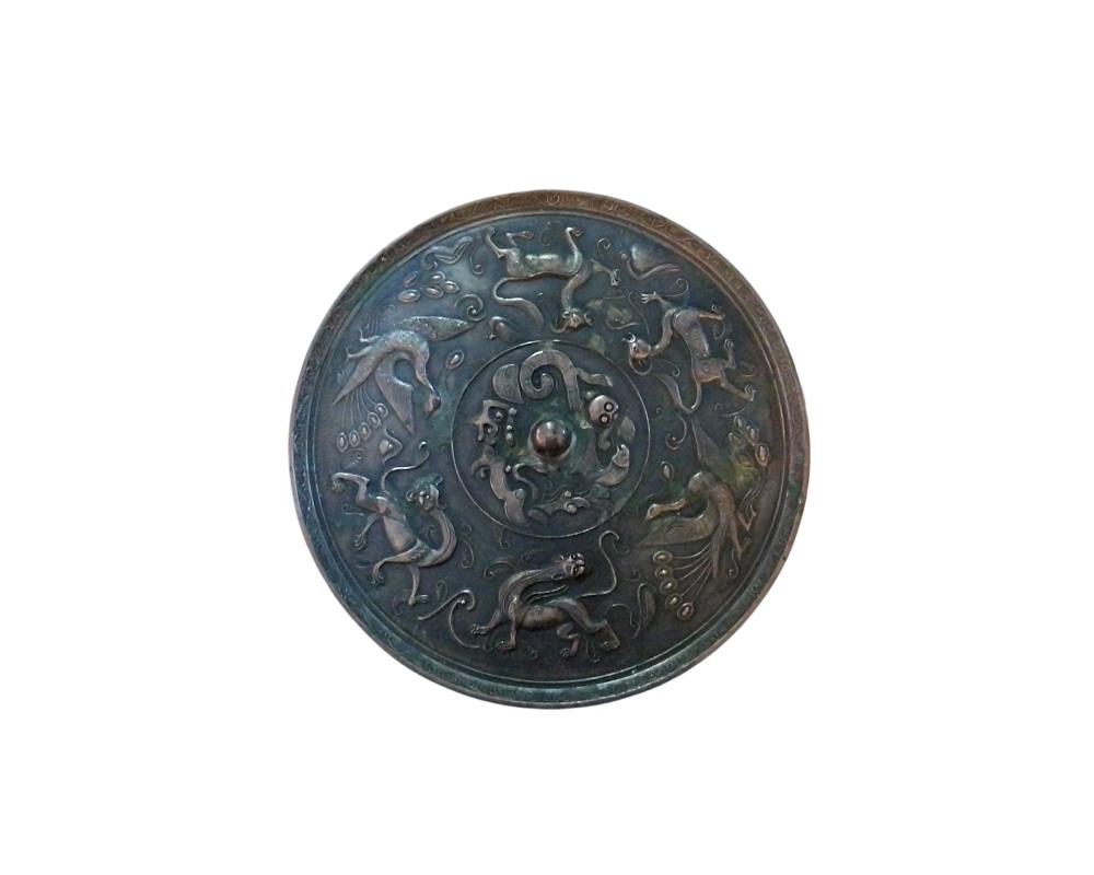 espejo circular de bronce con un acabado oscuro y envejecido, caracterizado por presentar un elaborado diseño en relieve en su superficie alquiler para eventos, publicidad, peliculas y series
