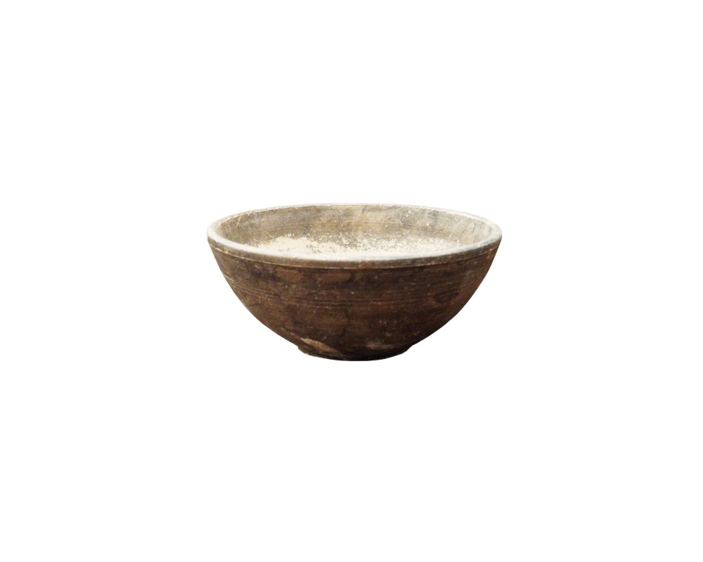 A small traditional ceramic bowl with a hemispherical design, characterised by an exterior finish in dark, earthy tones with subtle striations; available for hire for events, advertising, films and TV series