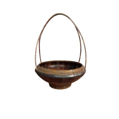 cuenco hondo de madera con una base circular de soporte que presenta detalles grabados de patrones geométricos, caracterizada por un cuerpo cóncavo de tonos oscuros y altas asas arqueadas que se extienden desde los laterales alquiler para evento,s publicidad, peliculas y series