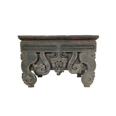 A low table or altar in a traditional Oriental style, made of wood with dark finishes, characterised by a rectangular top and intricately carved supports featuring curved shapes and interlaced ornamental motifs; available for hire for events, advertising, films and TV series