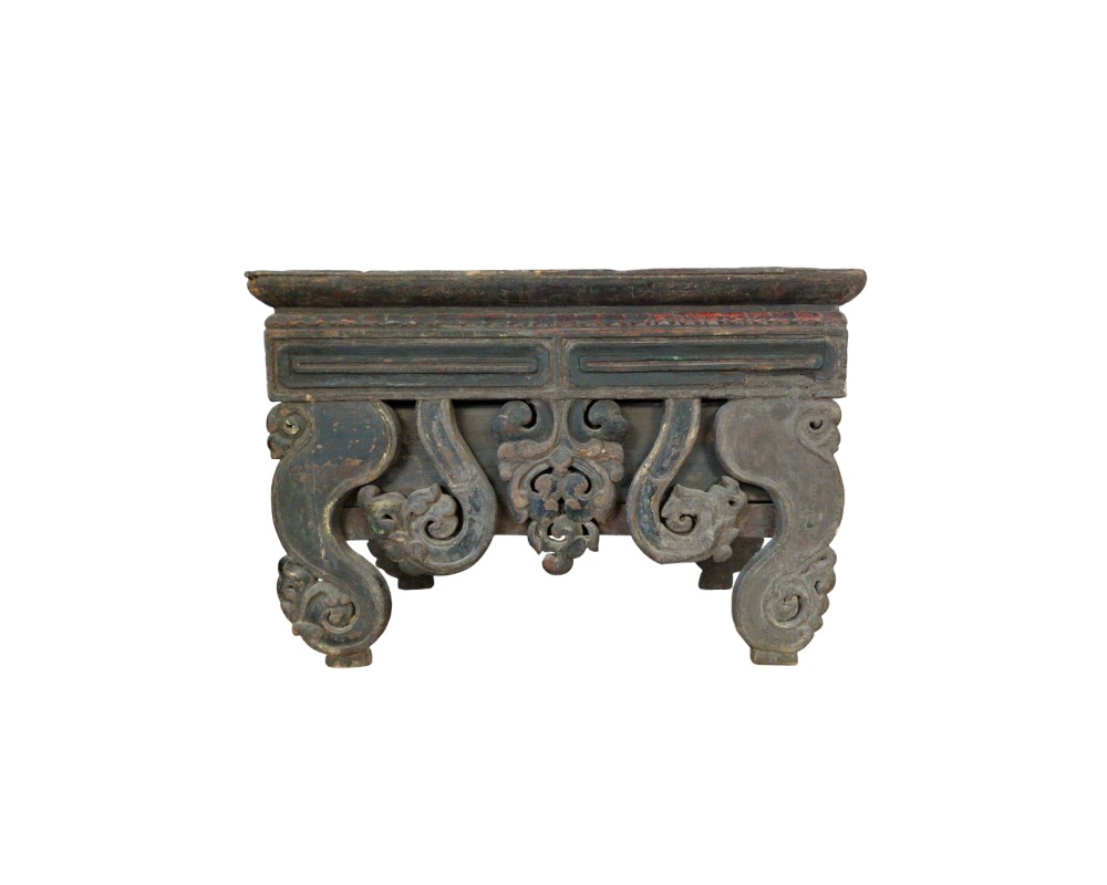 A low table or altar in a traditional Oriental style, made of wood with dark finishes, characterised by a rectangular top and intricately carved supports featuring curved shapes and interlaced ornamental motifs; available for hire for events, advertising, films and TV series
