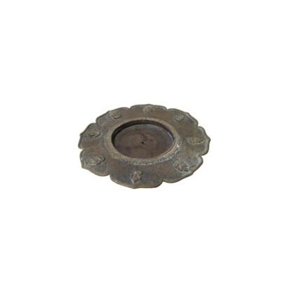 A metal plate with an antique appearance and dark tones, characterised by a lobed outer rim adorned with small circular reliefs, a background decorated with detailed engravings, and a central circular recess featuring a small perforation; available for hire for events, advertising, films and TV series