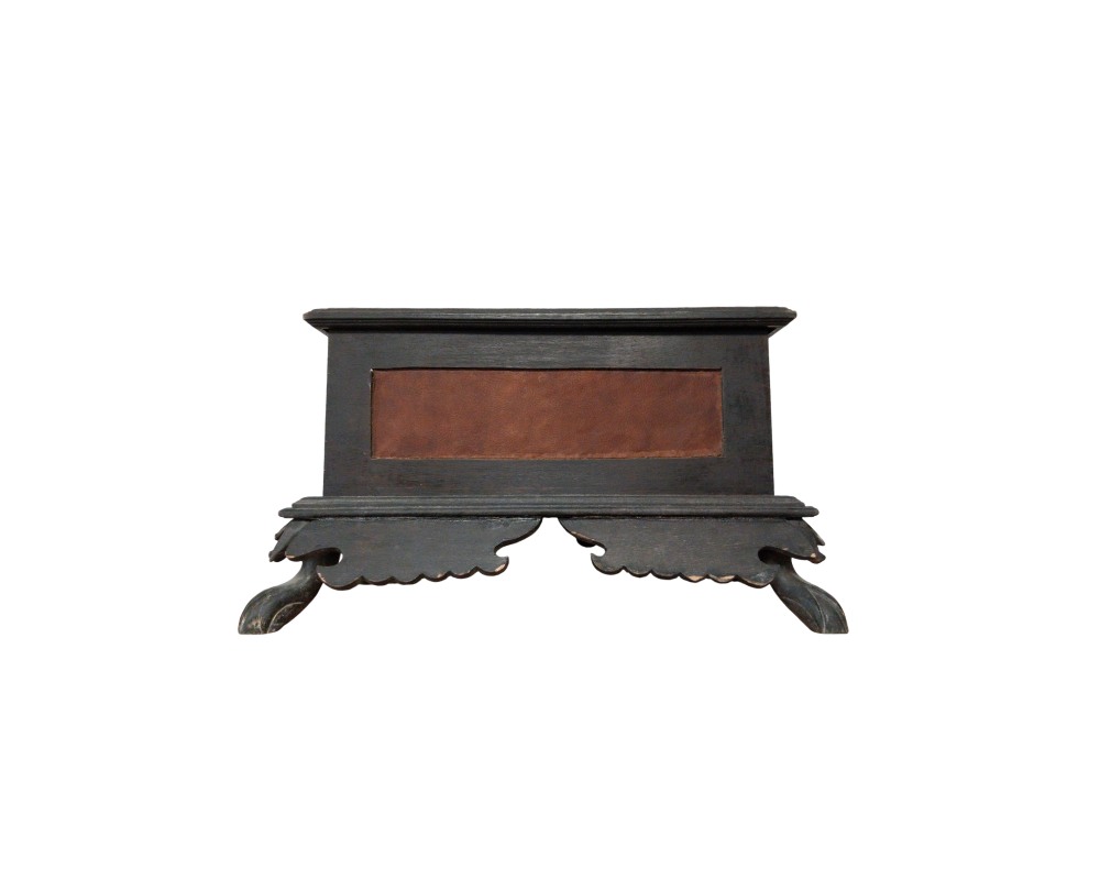 A rectangular wooden stand in dark tones, featuring a central brown-textured panel on the front, stepped mouldings at the top and bottom, and elaborate legs with lobed-edge skirts that provide both stability and style. Available for hire for events, advertising, films and TV series.