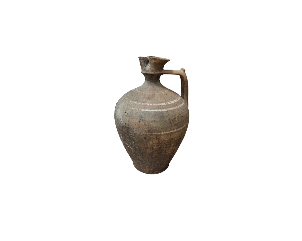 A rustic-looking ceramic jug in earthy tones, characterised by a sturdy, globular body, a practical side handle and clear decorative lines engraved around its surface; available for hire for events, advertising, films and TV series