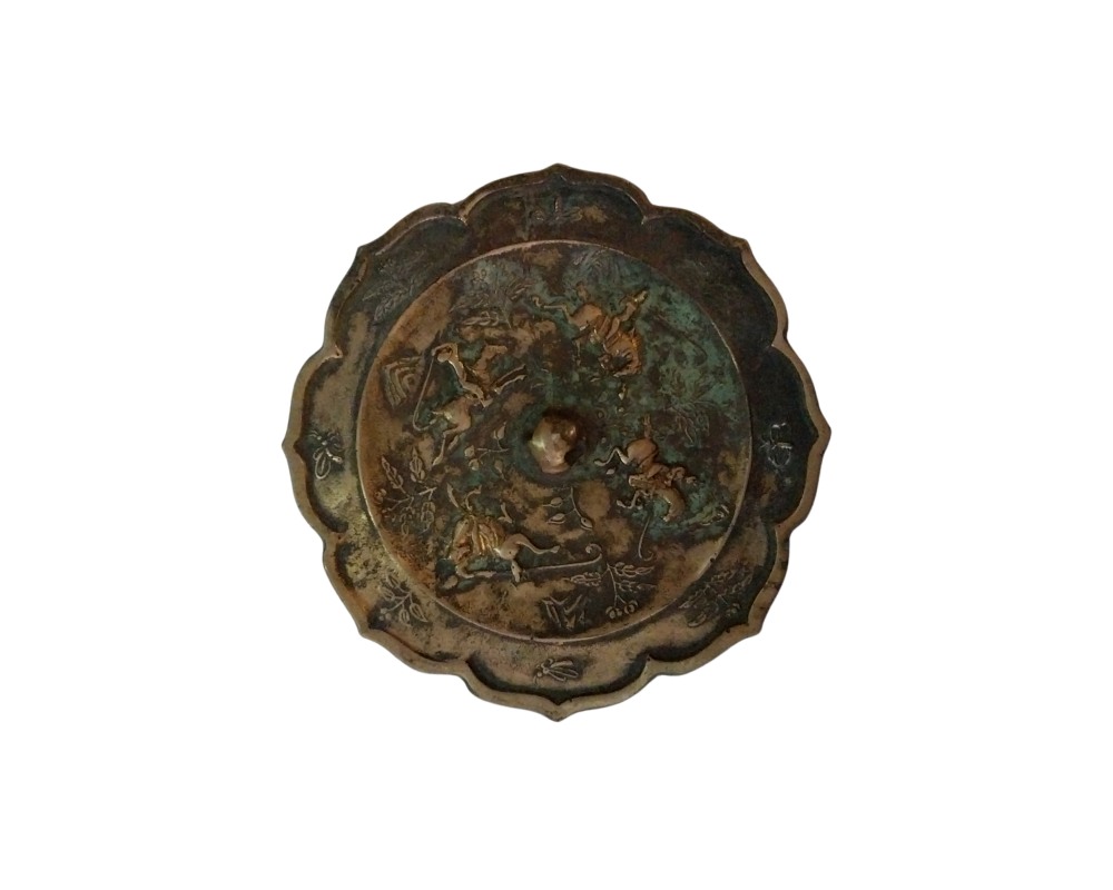 Antique bronze mirror with a distinctive lobed edge and an aged finish with a greenish patina; available for hire for events, advertising, films and TV series