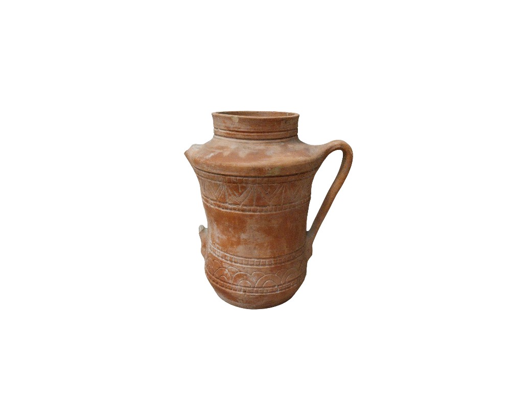 Terracotta ceramic jug in earthy tones, characterised by a sturdy cylindrical body, a practical side handle, a narrow neck and decorative bands featuring geometric relief engravings along its surface; available for hire for events, advertising, films and TV series