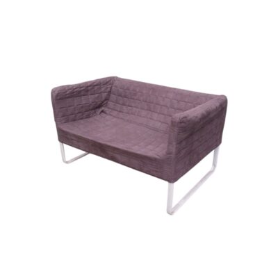 A modern, vintage-style two-seater sofa, characterised by its enveloping shape, upholstered in dark grey fabric with a distinctive grid-patterned quilted design, supported by a sturdy white tubular frame. Available for hire for events, advertising, films and TV series.