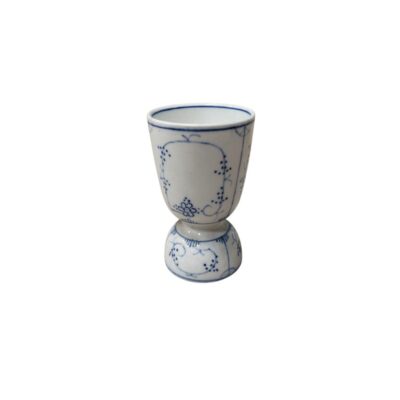 A small ceramic vessel in the shape of a cup or egg cup, characterised by a stylised design with a bulbous base and a flared body against a white background, delicately decorated with fine floral and geometric motifs in shades of cobalt blue; available for hire for events, advertising, films and TV series