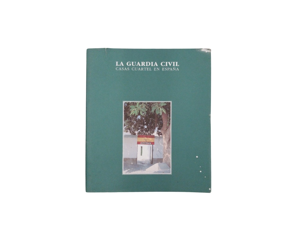 libro de tonos verdes caracterizado por el título institucional "LA GUARDIA CIVIL. CASAS CUARTEL EN ESPAÑA" impreso en la parte superior y una fotografía central enmarcada que muestra la entrada de un cuartel tradicional con la bandera de España alquiler para eventos, publicidad, peliculas y series
