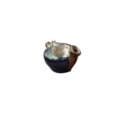 A globular ceramic vessel characterised by a rounded body, a pronounced lateral spout and a surface covered in a rich metallic glaze with iridescent and shimmering tones that combine dark hues; available for hire for events, advertising, films and TV series