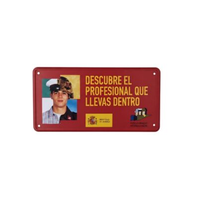 cartel rectangular de metal de fondo rojo con orificios en las esquinas para su fijación, caracterizado por mostrar el lema "DESCUBRE EL PROFESIONAL QUE LLEVAS DENTRO", junto con la imagen dividida de un joven con diferentes uniformes militares, el logotipo oficial del Ministerio de Defensa de España y el emblema de las Fuerzas Armadas Profesionales alquiler para eventos, publicidad, peliculas y series