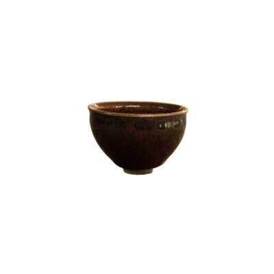 taza pequeña de cerámica de forma redondeada y base estrecha, caracterizada por presentar un esmalte brillante en tonos marrones oscuros con sutiles matices y variaciones de color en su superficie alquiler para eventos, publicidad, peliculas y series