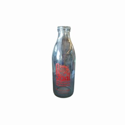 botella de vidrio transparente de época, datada en torno a la década de 1950. Presenta una clásica silueta cilíndrica de cuello estrecho con borde reforzado y una llamativa serigrafía publicitaria original en color rojo en su cuerpo central con el distintivo comercial "Sual" alquiler para eventos, publicidad, peliculas y series