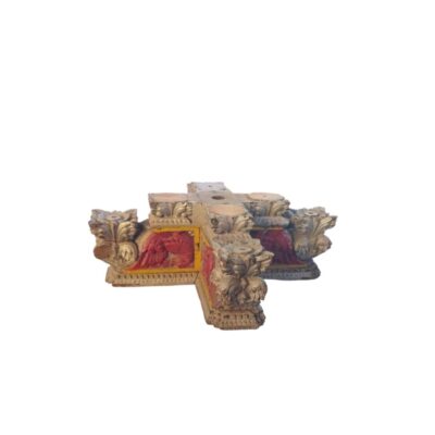 An architectural element in the shape of a cross, characterised by intricate ornamental carving featuring floral and zoomorphic details, finished in aged gold and red tones; available for hire for events, advertising, films and TV series