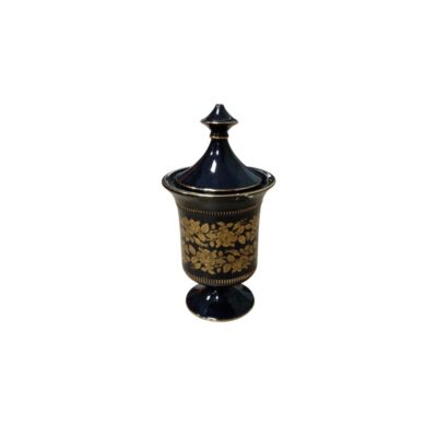 A porcelain container with a lid in a deep dark blue shade, characterised by a design featuring a pedestal base, edges and borders with gold filigree, and a central body decorated with a gold floral motif; available for hire for events, advertising, films and TV series