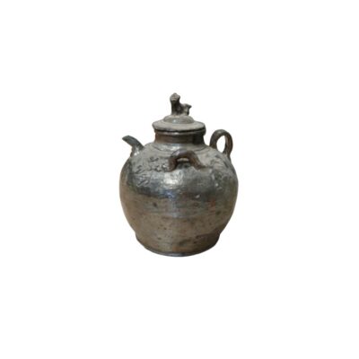Traditional ceramic jug with an aged finish in dark and greyish tones, characterised by a sturdy, globular body, a spout, side handles and a lid crowned by a small sculpted figure; available for hire for events, advertising, films and TV series