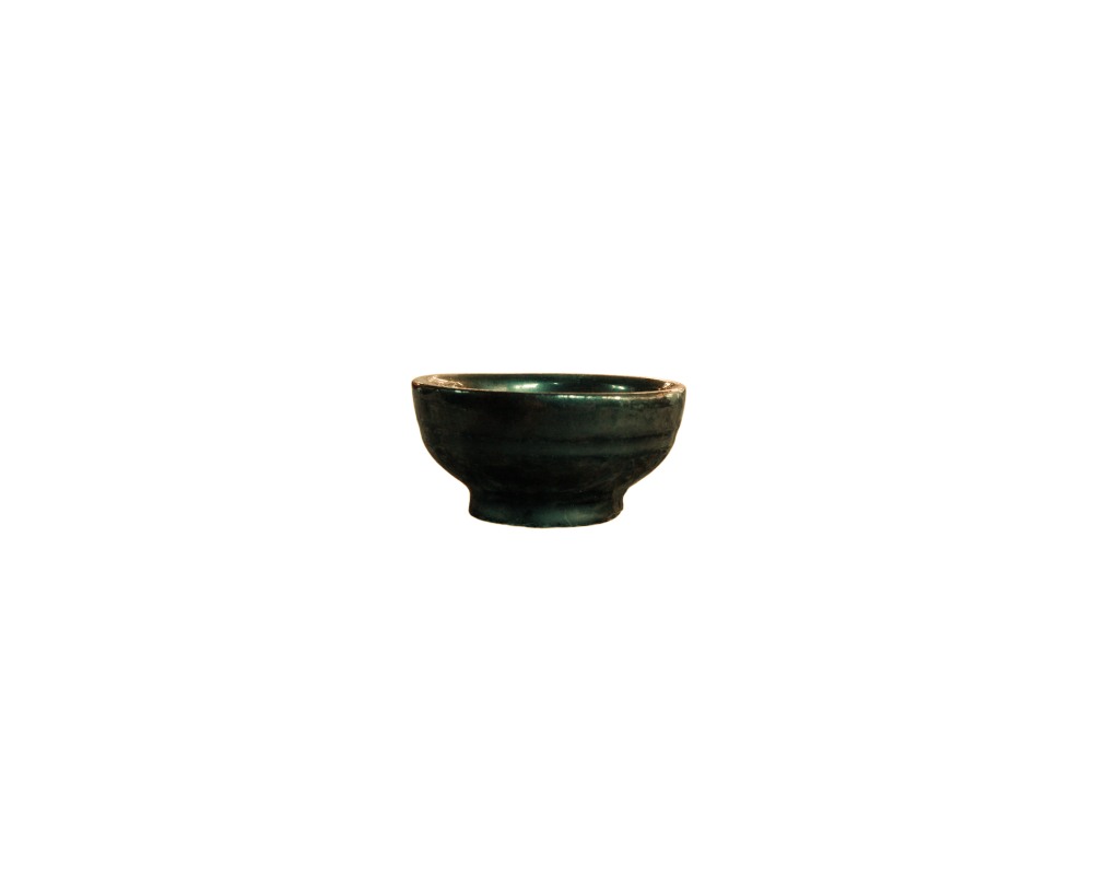taza pequeña de cerámica de forma redondeada con base destacada, caracterizada por presentar un acabado esmaltado brillante en tonos verdes oscuros o azulados alquiler para eventos, publicidad, peliculas y series