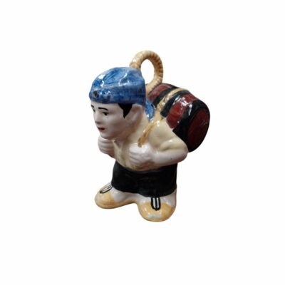 An oriental-inspired ceramic figurine depicting a traditional character, hunched over whilst carrying a barrel tied with ropes on his back, wearing a blue headscarf, a light-coloured shirt and dark trousers; available for hire for events, advertising, films and TV series