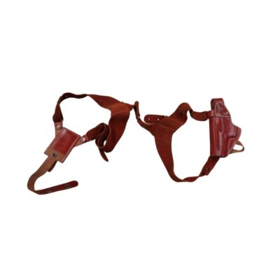 funda de pistola de tipo axilar o de hombro confeccionada en cuero marrón de alta calidad, caracterizada por un diseño de arneses ajustables con costuras reforzadas, un soporte para cargador o accesorio y una funda rígida moldeada para el arma alquiler para eventos, publicidad, peliculas y series