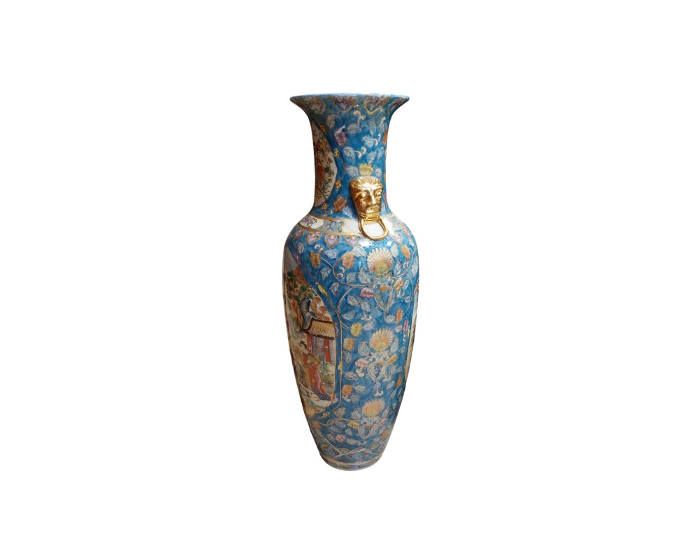 A tall porcelain vase featuring a blue-toned background covered in intricate floral motifs, panels depicting traditional figurative scenes and striking gold embossed details, including a mask with a pendant ring around the neck; available for hire for events, advertising, films and TV series