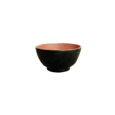 cuenco de cerámica de forma redondeada y base anular destacada, caracterizado por presentar un contraste cromático entre su exterior de tono oscuro y mate y su interior de acabado en tonos rojizos alquiler para eventos, publicidad, peliculas y series