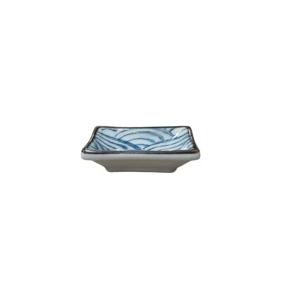 pequeño plato de cerámica de forma cuadrada con bordes ligeramente elevados y un ribete oscuro, decorado en su interior con un diseño tradicional de ondas o líneas curvas en tonos azules sobre fondo claro alquiler para eventos, publicidad, peliculas y series