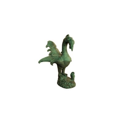 figura ornamental de metal con acabado de pátina verde envejecida, caracterizada por representar a un ave estilizada de tipo mitológico o fénix con el plumaje detallado, cola abierta y posada sobre una base decorada que incluye una pequeña figura secundaria alquiler para eventos, publicidad, peliculas y series