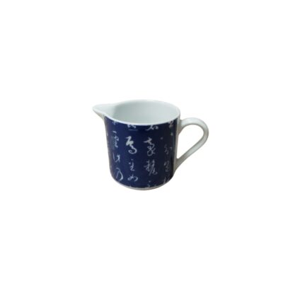 Glazed ceramic milk jug with a side handle and a spout, characterised by a body in a deep cobalt blue colour decorated with inscriptions or cursive calligraphic motifs in white, contrasting with the plain white interior; available for hire for events, advertising, films and TV series