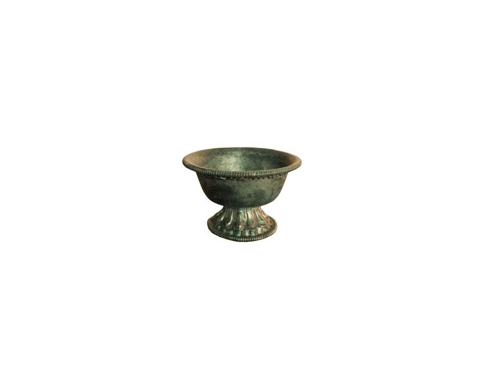 Metal bowl with an aged finish in shades of green and dark colours, characterised by a classic design with a corded rim, a concave body and a pedestal base decorated with fluted reliefs; available for hire for events, advertising, films and TV series