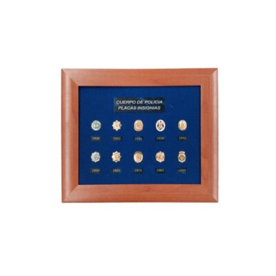 cuadro de presentación con marco de madera y fondo de terciopelo azul, diseñado para exhibir una colección de diez miniaturas de placas e insignias históricas del Cuerpo de Policía, ordenadas cronológicamente con sus respectivos años desde 1920 hasta 1989 y una placa identificativa superior que reza "CUERPO DE POLICIA PLACAS INSIGNIAS" alquiler para eventos publicidad, peliculas y series