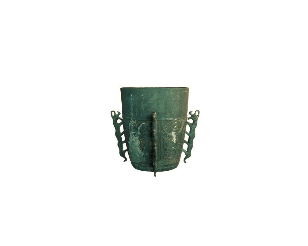 An antique-looking metal container, characterised by an aged green patina, traditional-style decorative reliefs on its body, incised lettering on the top and two zoomorphic handles on either side; available for hire for events, advertising, films and TV series