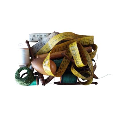 lote de utensilios de costura y mercería clásica de época, que incluye cintas métricas flexibles numeradas, bobinas de hilo de diversos colores, madejas y carretes de madera tradicionales, además de una caja de almacenamiento vintage con restos de papel de seda interior alquiler para eventos, publicidad, peliculas y series