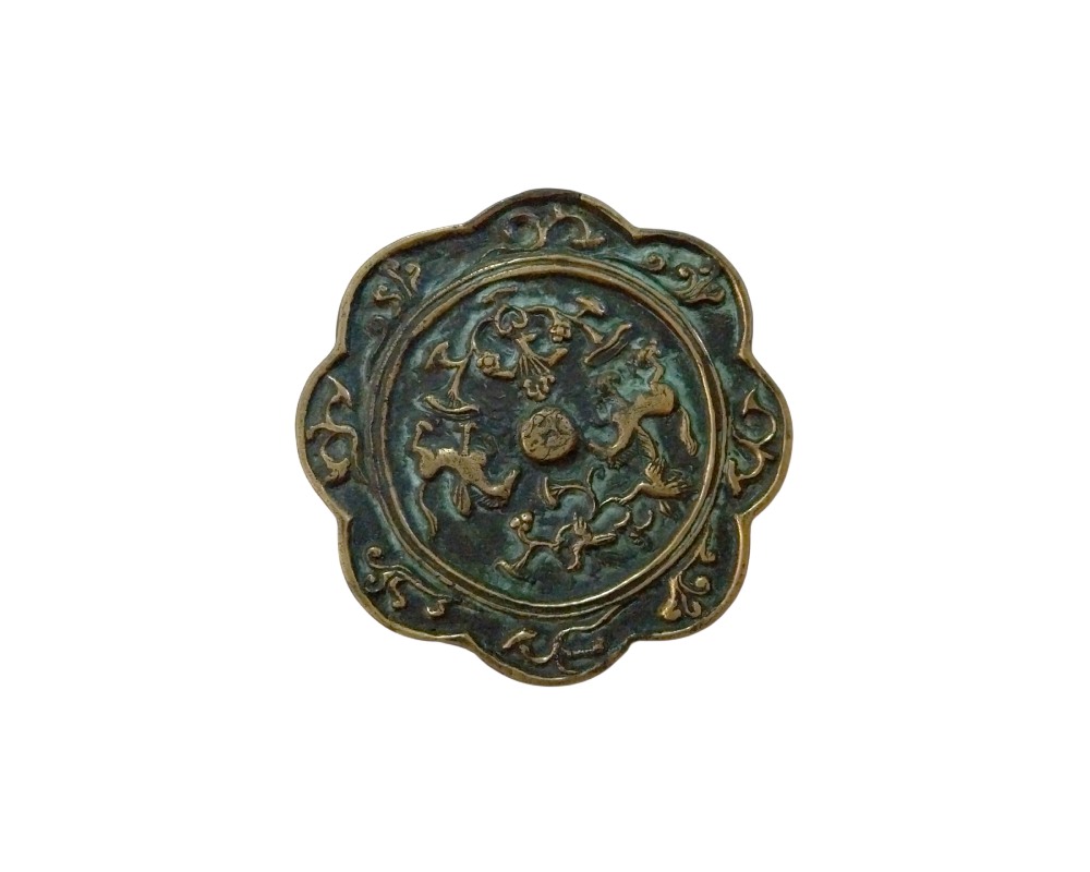Antique bronze mirror with a distinctive lobed or petal-like design along its outer edge; available for hire for events, advertising, films and TV series