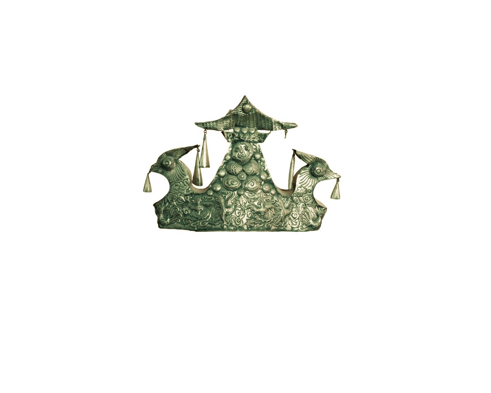 tocado metálico de estilo tradicional asiático, caracterizado por un acabado envejecido en tonos verdosos y dorados, decorada con relieves de figuras y criaturas mitológicas, un remate superior en forma de techumbre o templete y pequeños colgantes en forma de campanilla distribuidos en los laterales alquiler para eventos, publicidad, peliculas y series