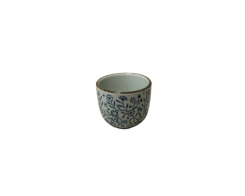 A small glass with a slightly domed cylindrical body, characterised by a finely contoured rim and a white glaze decorated with a dense pattern of floral motifs and intertwined stems in shades of cobalt blue; available for hire for events, advertising, films and TV series