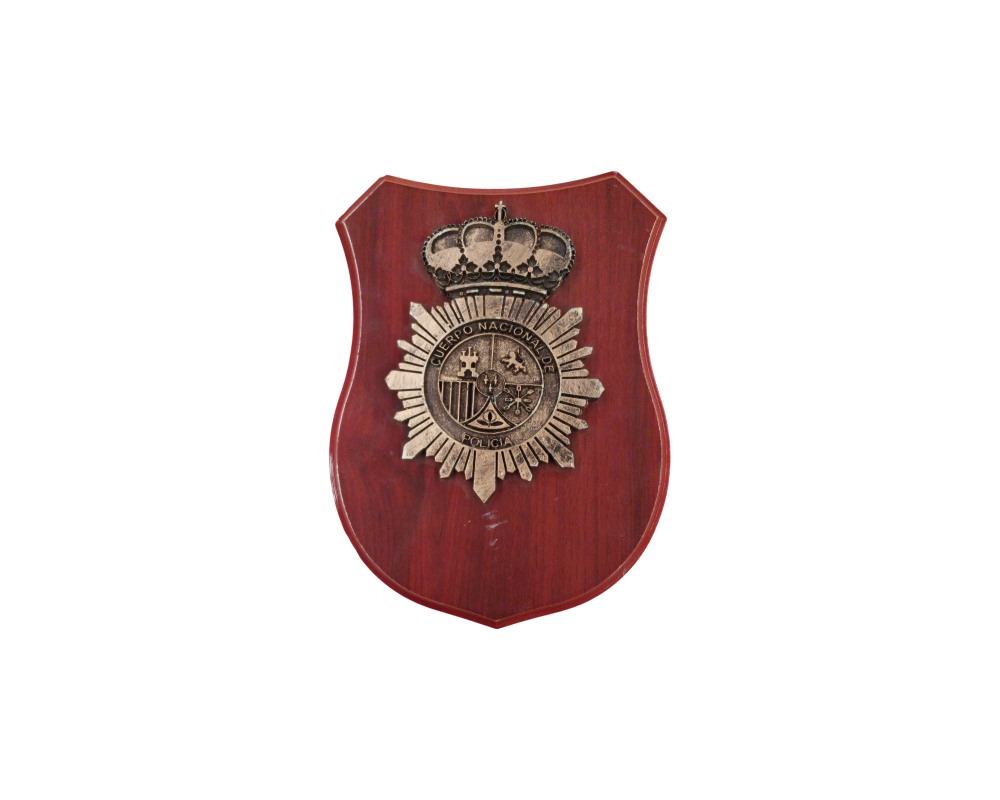 metopa decorativa de forma heráldica con base de madera en tonos rojizos, caracterizada por incorporar en el centro un emblema metálico en relieve envejecido correspondiente al Cuerpo Nacional de Policía de España, con su estrella de ocho puntas y la corona real alquiler para eventos, publicidad, peliculas y series