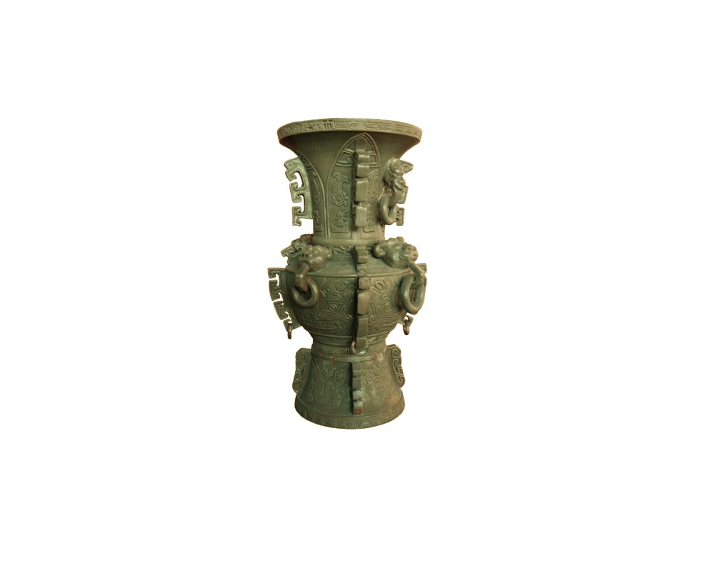 jarrón metálico de estilo antiguo con un acabado de pátina verde envejecida, caracterizado por su cuerpo profusamente decorado con grabados geométricos tipo zun, cabezas de animales o dragones en relieve y asas con anillos colgantes alquiler para eventos, publicidad, peliculas y series