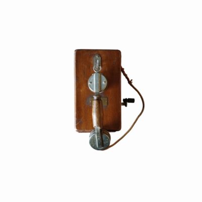 teléfono de pared histórico de época, caracterizado por su sólida carcasa rectangular de madera noble provista de elementos metálicos, manivela lateral y un auricular de tipo monófono con mango de madera central alquiler para eventos, publicidad, peliculas y series