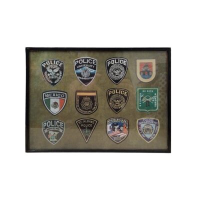 cuadro de presentación con marco oscuro, diseñado para exhibir una colección de doce parches e insignias bordadas de diversos cuerpos policiales y de seguridad nacionales e internacionales (incluyendo agencias de Estados Unidos, México, España y Puerto Rico) alquiler para eventos, publicidad, peliculas y series