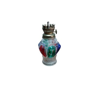 pequeña lámpara de aceite de época, caracterizada por su cuerpo de vidrio tallado con relieves texturizados y detalles en llamativos colores (rojo, verde y azul), coronado por un mechero metálico superior con rueda de regulación y corona decorativa alquiler para eventos, publicidad, peliculas y series