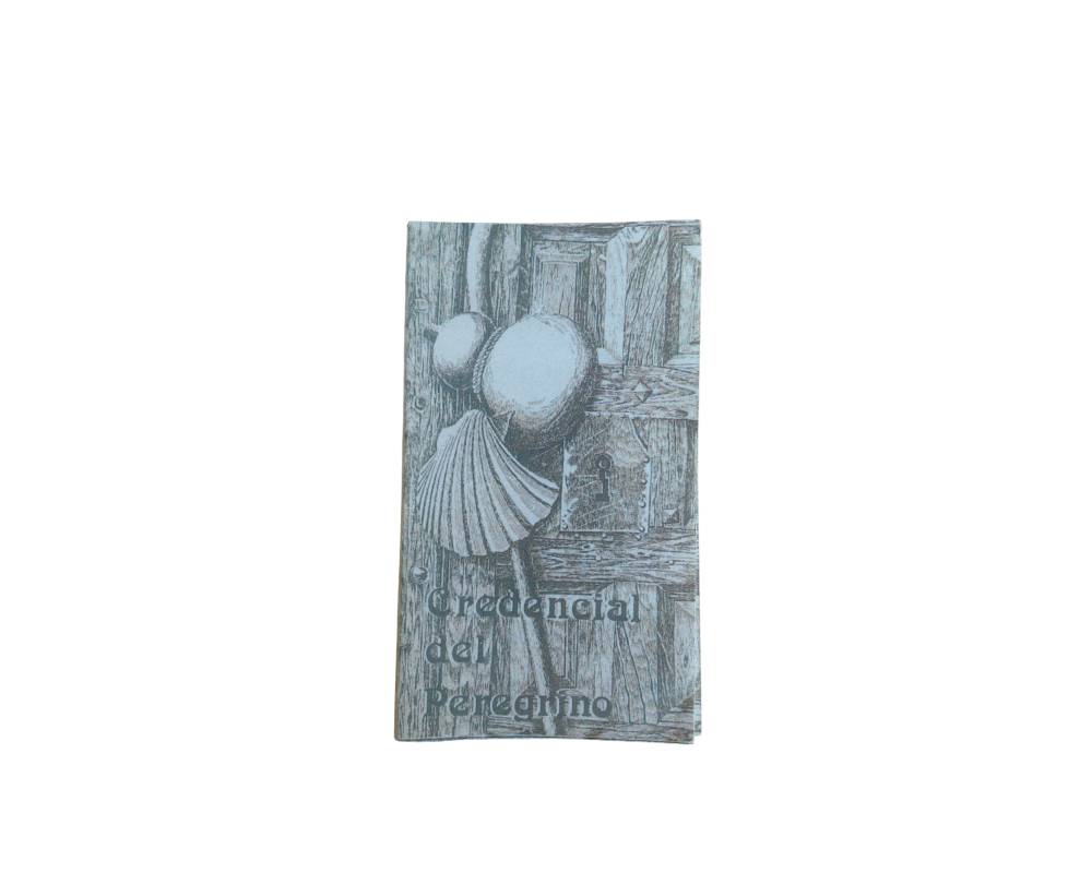 an official booklet in portrait format entitled ‘Pilgrim’s Credential’, featuring a cover illustrated with a classical engraving depicting traditional symbols of the Way of St James, such as the scallop shell and the gourd hanging above a wooden door; available for hire for events, advertising, films and TV series