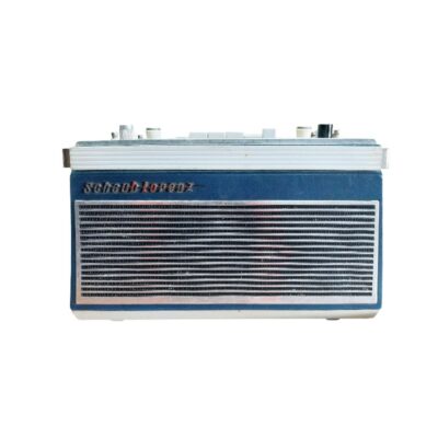 radio portátil de época de la marca Schaub-Lorenz, caracterizada por su carcasa rectangular en tonos azulados y plateados, un amplio panel frontal con una fina rejilla metálica de lamas horizontales y el logotipo de la firma en la parte superior alquiler para eventos, publicidad, peliculas y series