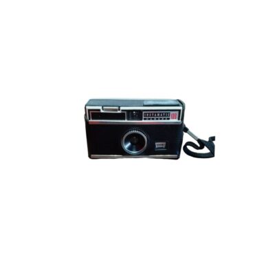cámara fotográfica analógica compacta de la reconocida marca Kodak, modelo Instamatic 100, caracterizada por su cuerpo rectangular negro con detalles metálicos y blancos, y equipada con una correa de mano lateral alquiler para eventos, publicidad, peliculas y series
