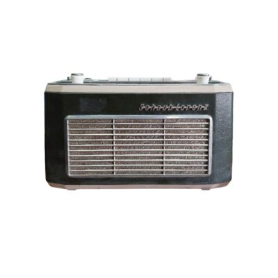 radio portátil de época de la marca Schaub-Lorenz, caracterizada por su carcasa rectangular en tonos oscuros y claros contrastados, un panel frontal con una rejilla metálica horizontal y el logotipo de la firma en la parte superior alquiler para eventos, publicidad, peliculas y series