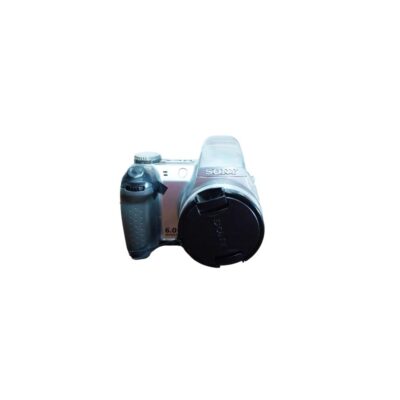 cámara fotográfica digital de la marca Sony con un diseño de cuerpo ergonómico en tonos plateados y oscuros, caracterizada por su empuñadura texturizada y un objetivo frontal provisto de su tapa protectora original alquiler para eventos, publicidad, peliculas y series