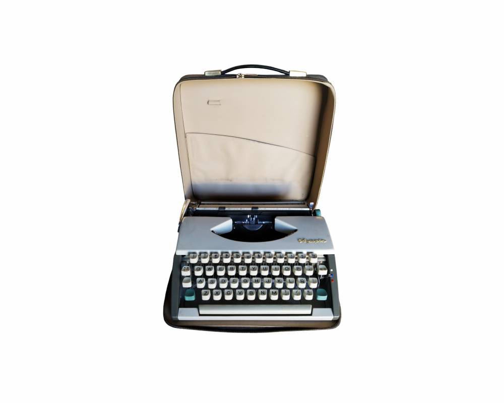 máquina de escribir portátil de diseño clásico de la marca Olympia, equipada con teclado en disposición QWERTY con eñe, cuerpo en tonos claros y su maletín de transporte rígido original con cremallera y asa alquiler para eventos, publicidad, peliculas y series