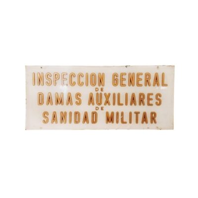 A rectangular plaque in landscape format with a light-coloured background and embossed or gold-coloured lettering bearing the official inscription ‘GENERAL INSPECTORATE OF MILITARY MEDICAL AUXILIARY LADIES’ – available for hire for events, advertising, films and TV series
