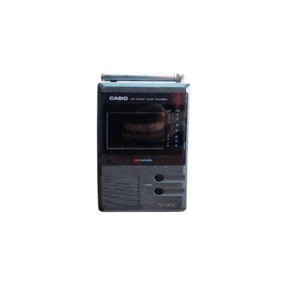 televisor portátil de bolsillo de época de la marca Casio (modelo TV-1400), caracterizada por su carcasa rectangular vertical de tonos oscuros, una antena telescópica superior, una pequeña pantalla LCD a color integrada y mandos de sintonía en el panel frontal alquiler para eventos, publicidad, peliculas y series